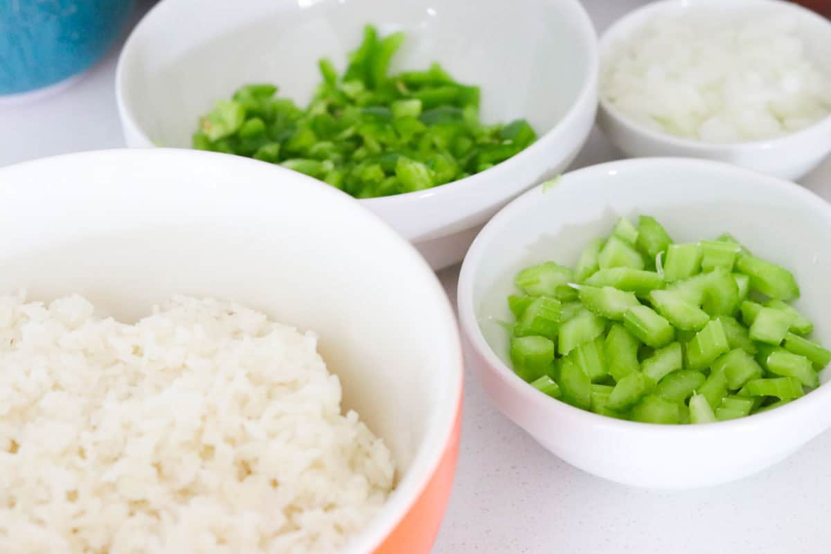 cooked rice, chopped bell pepper, chopped celery, and chopped onion in bowls