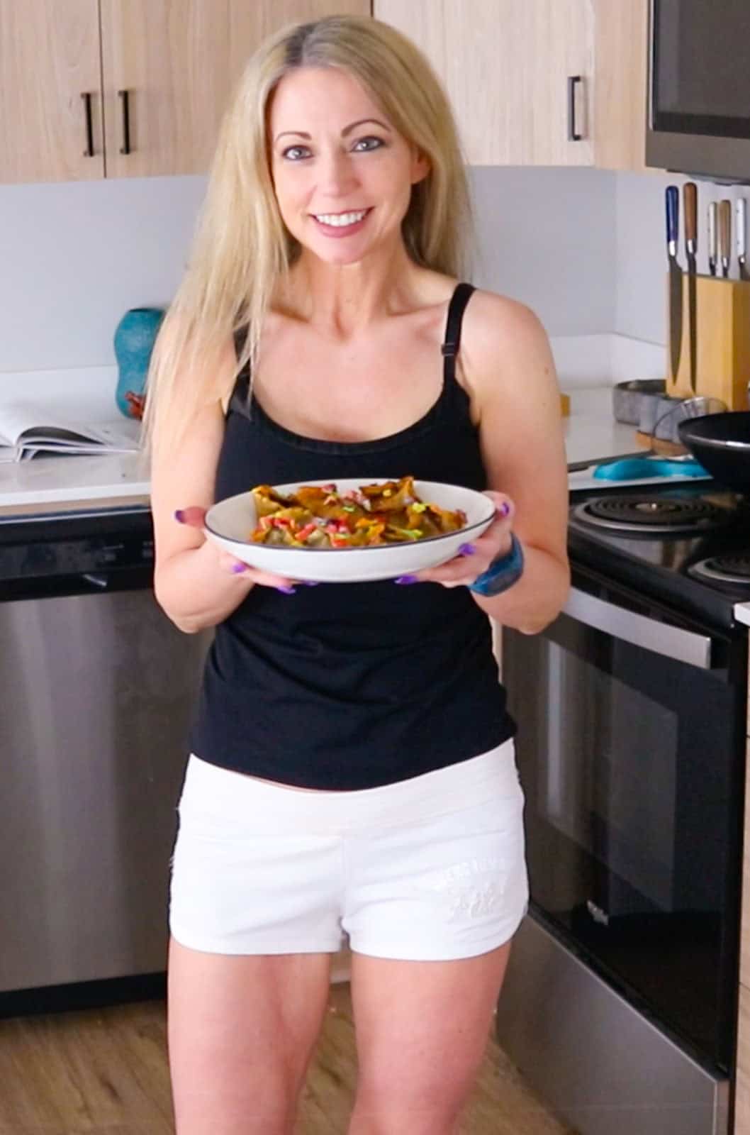 Kristin is holding a bowl with glam trash cake rangoons in it