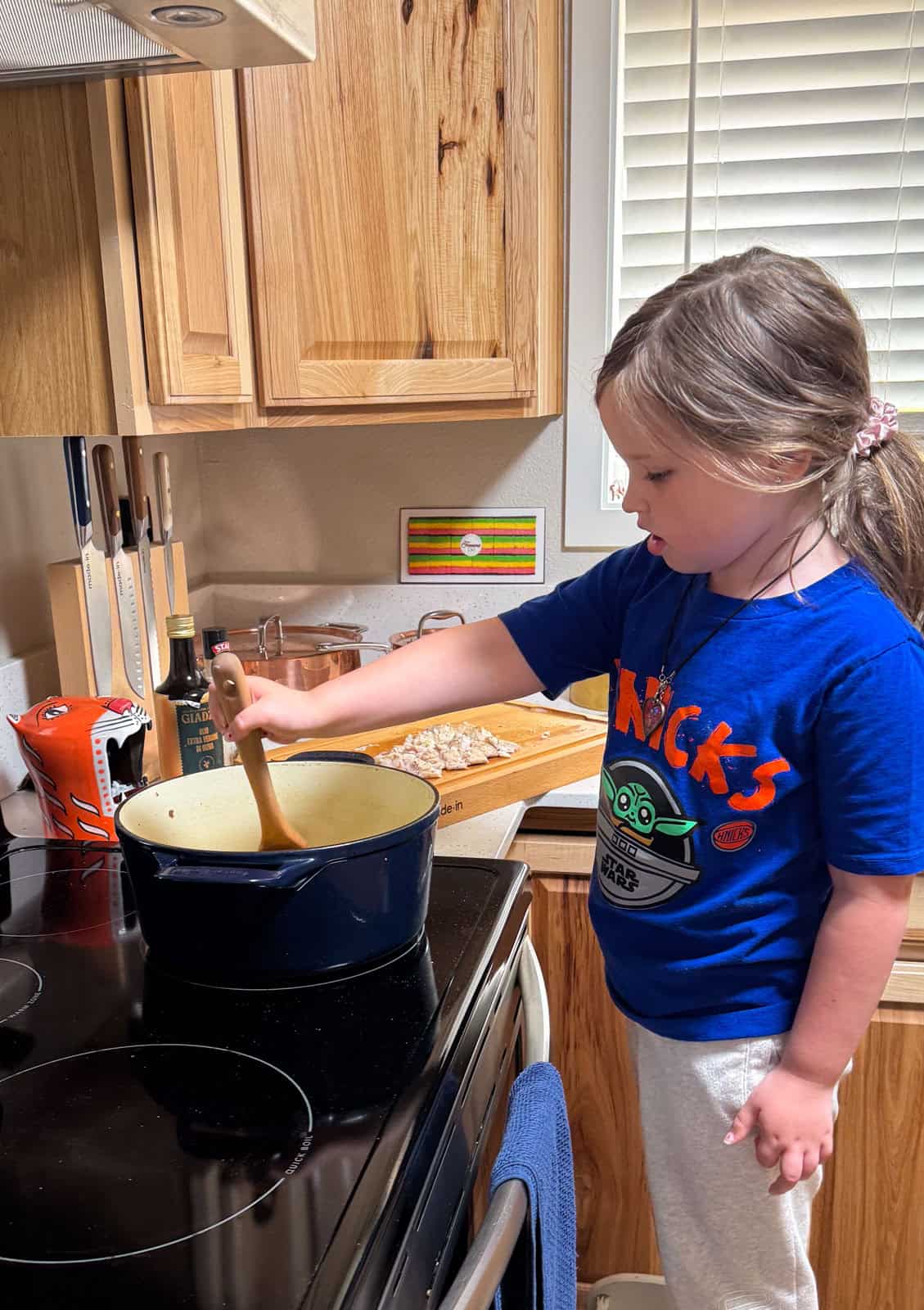 Katalina is stirring vindaye poisson ingredients in a Dutch oven