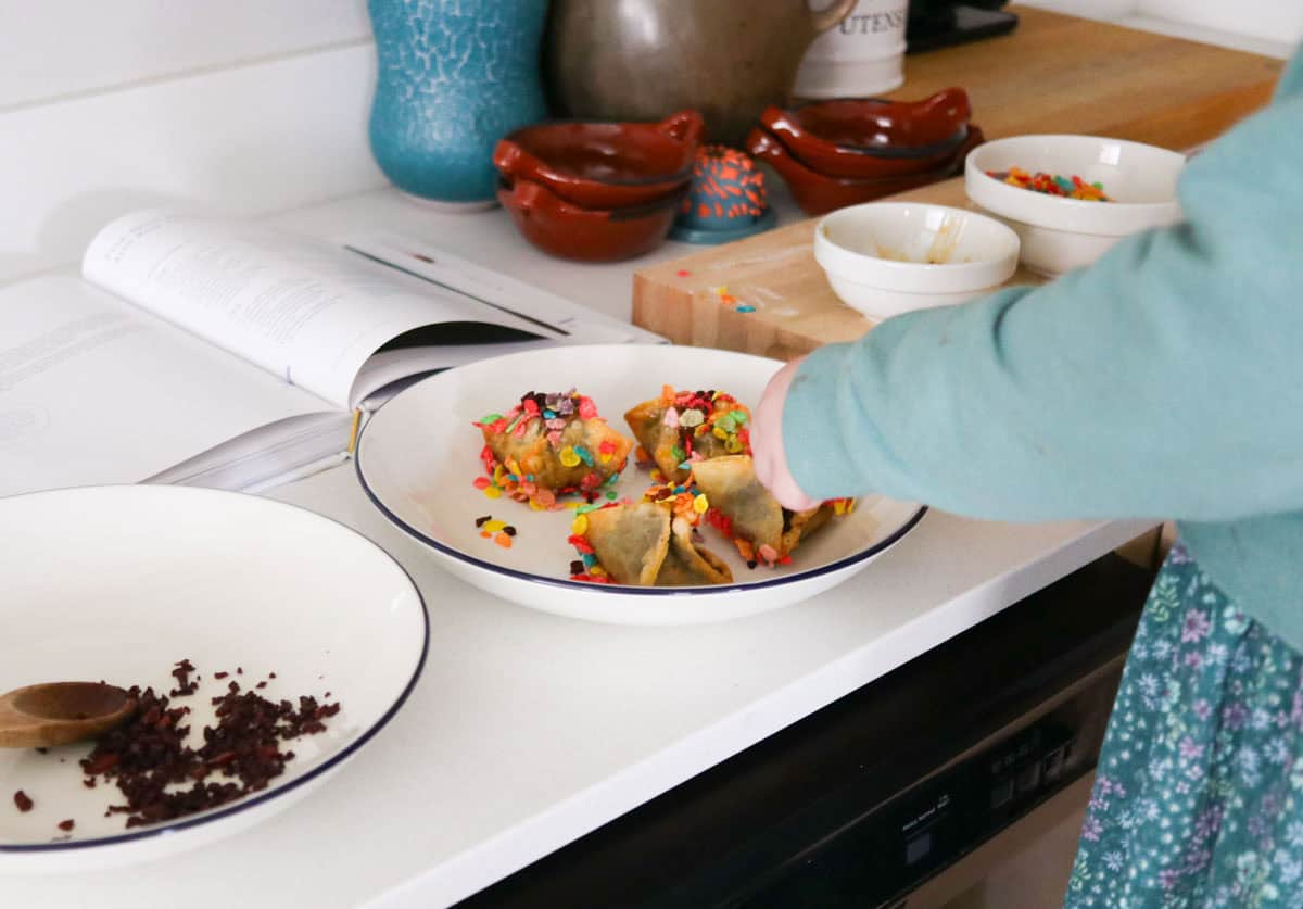 Katalina is adding cooked hot dog bits to a cake rangoon