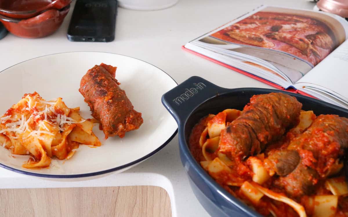Braciole beside pappardelle with marinara sauce