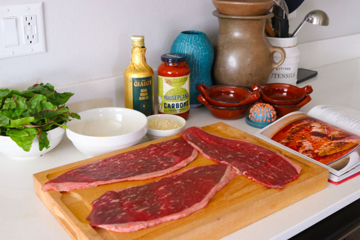 ingredients for making beef braciole minus the onion being chopped