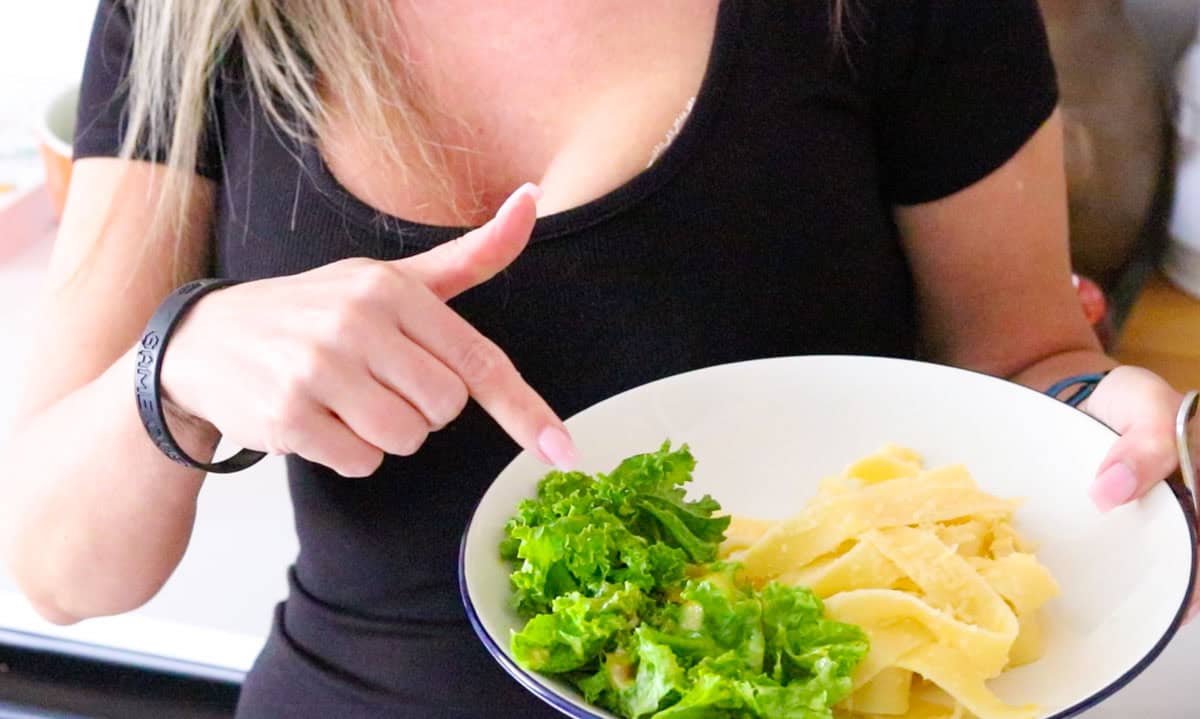 Kristin is pointing at the kale covered in caesar dressing