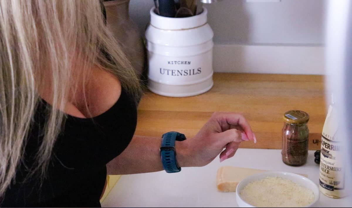 Kristin is grabbing a salty ingredient to add to the caesar dressing