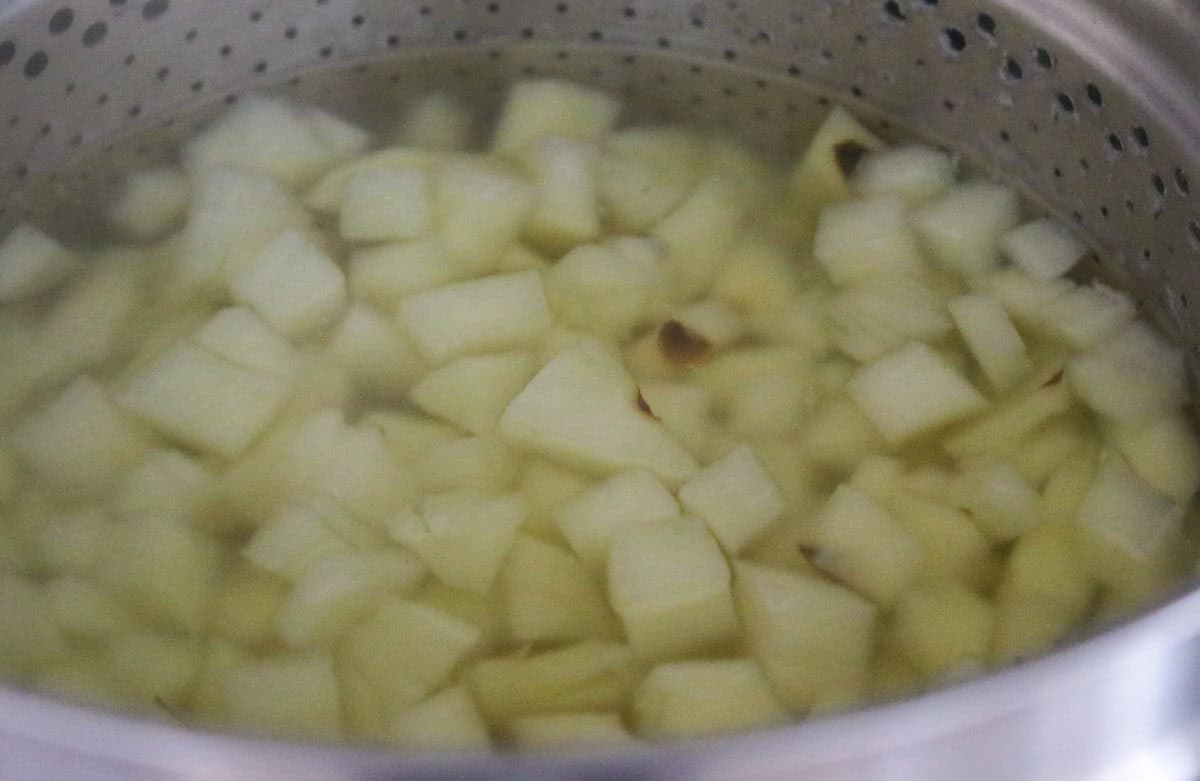 potatoes cooking in a stock pot with an insert