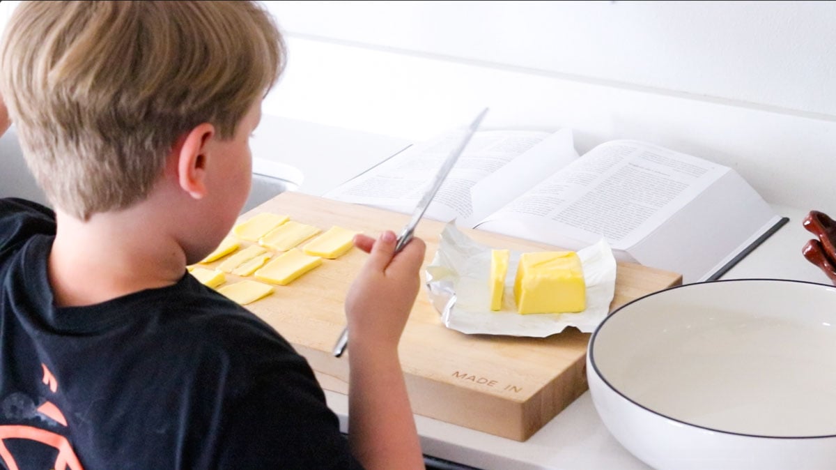 Noah is slicing way too much butter