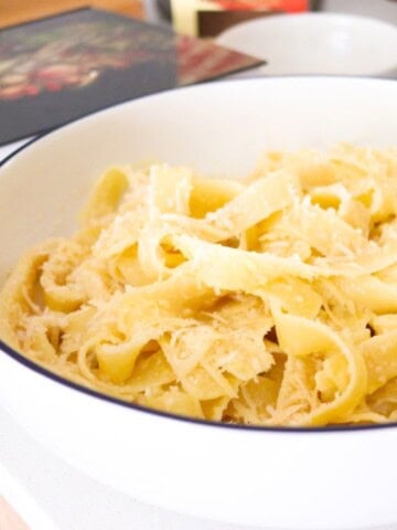 fettuccine alfredo in a serving bowl beside An Italian Feast