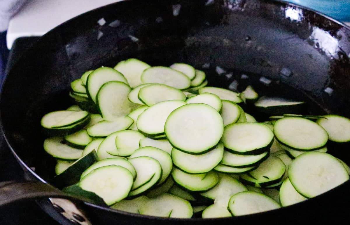 zucchini slices frying in a pan