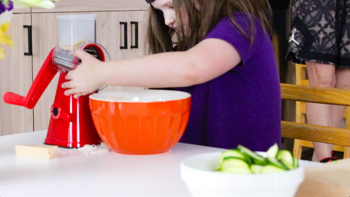 Kat is grating Parmesan cheese using a NutriSlicer