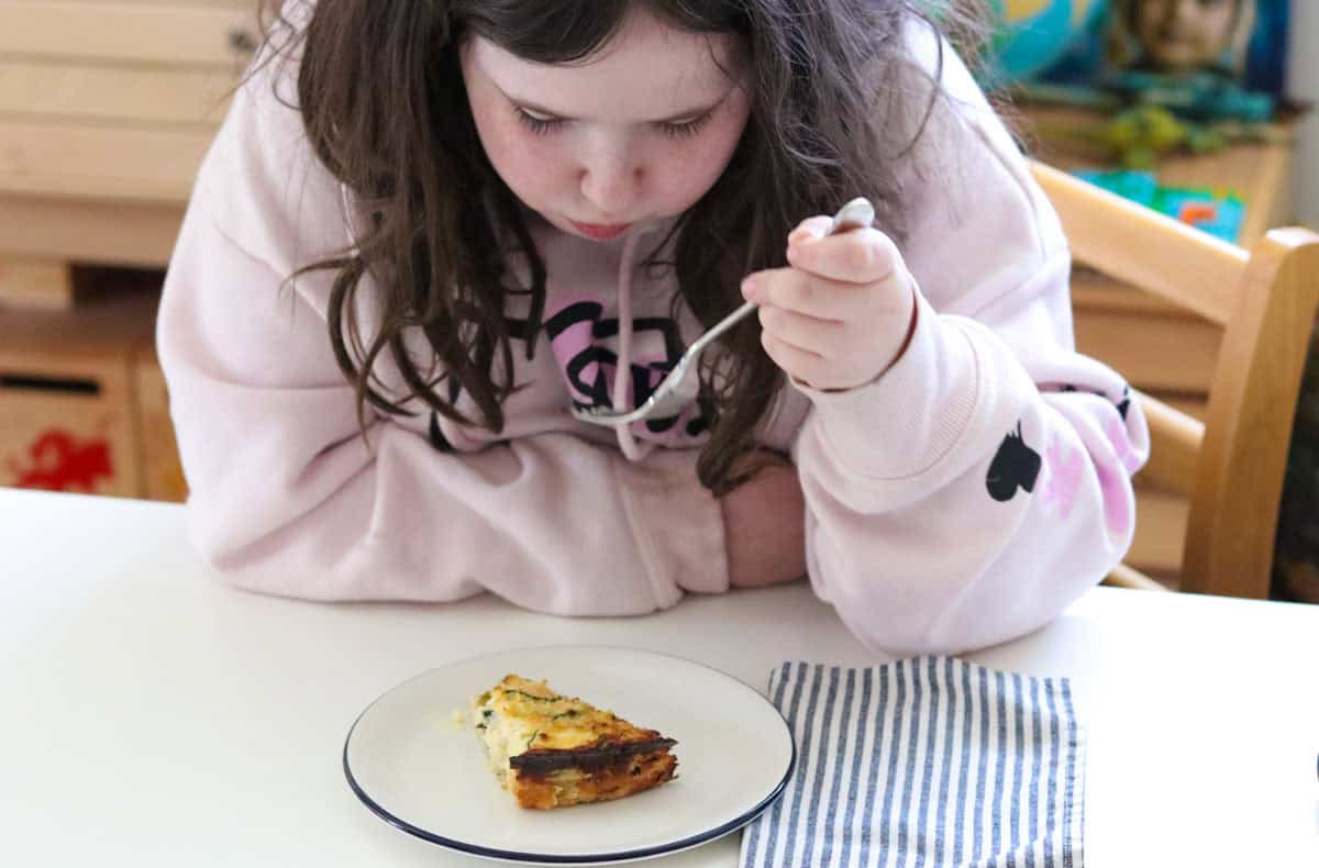 Kaia is eating a piece of zucchini casserole