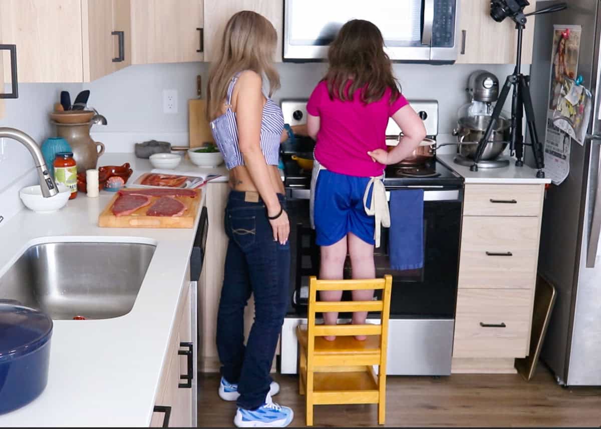 Kristin and Kat are cooking at the stove