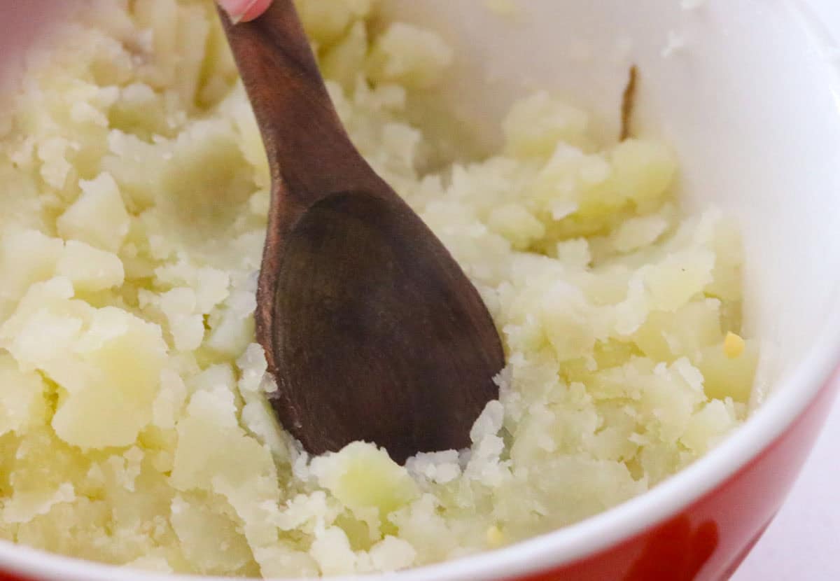 mashing potatoes with a spoon