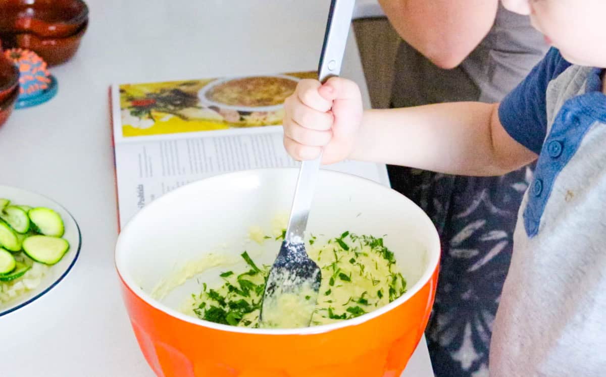 John is mixing ingredients in a bowl with a spoonula