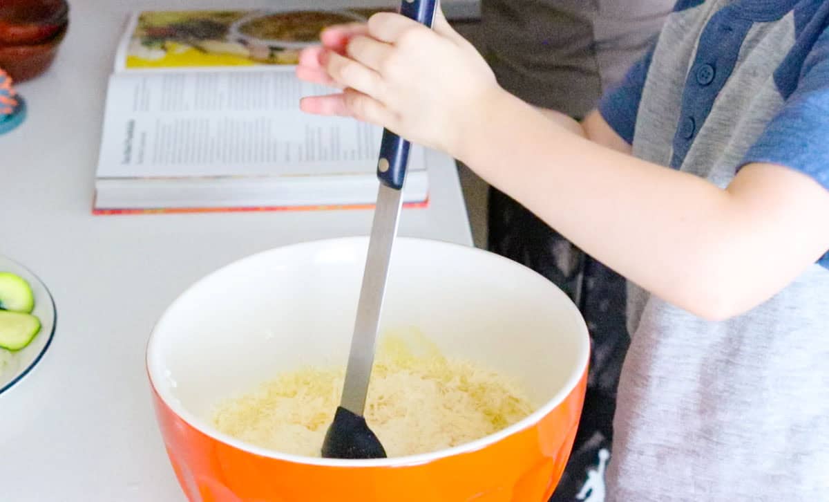 John is combining eggs, cheese, milk, and yogurt using a spoonula