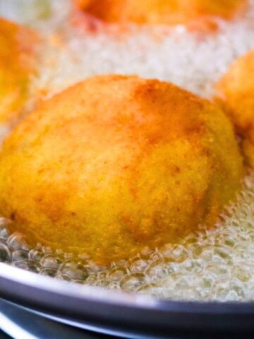 papas rellenas frying in a wok