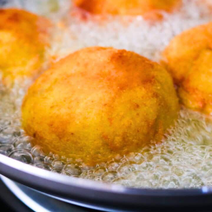 papas rellenas frying in a wok