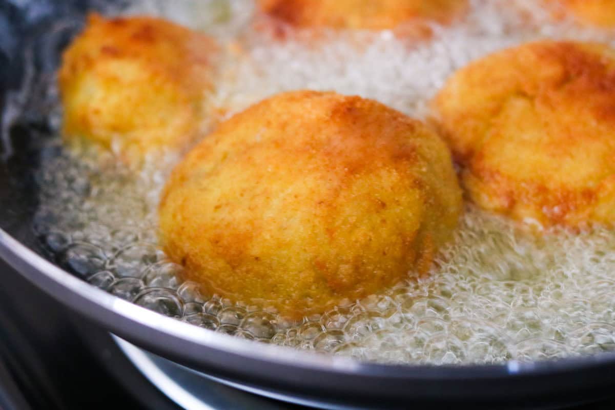 papas rellenas frying in a wok