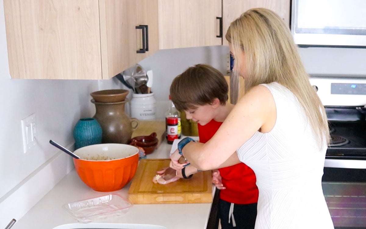 Kristin is showing John how to cut into the chicken thighs