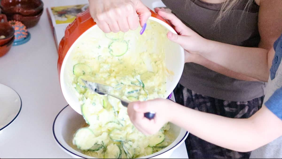 Kristin and John are transferring zucchini casserole to a pie dish to bake