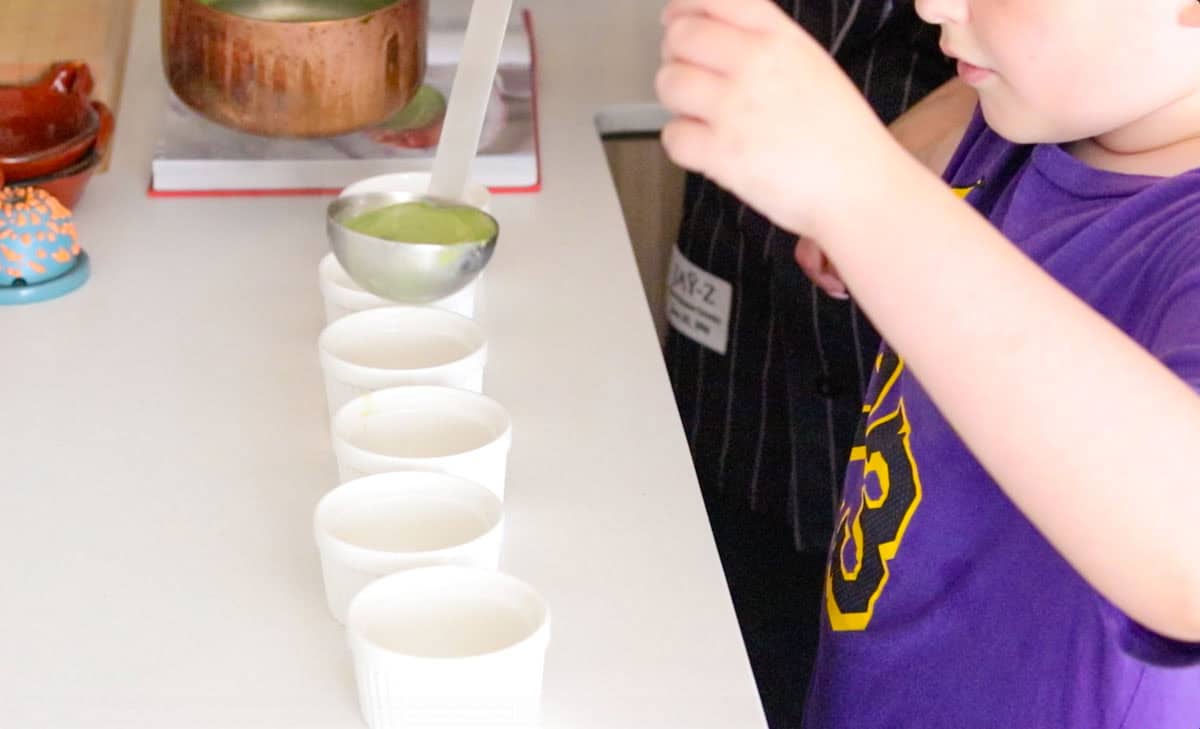 Noah is ladling panna cotta into ramekins