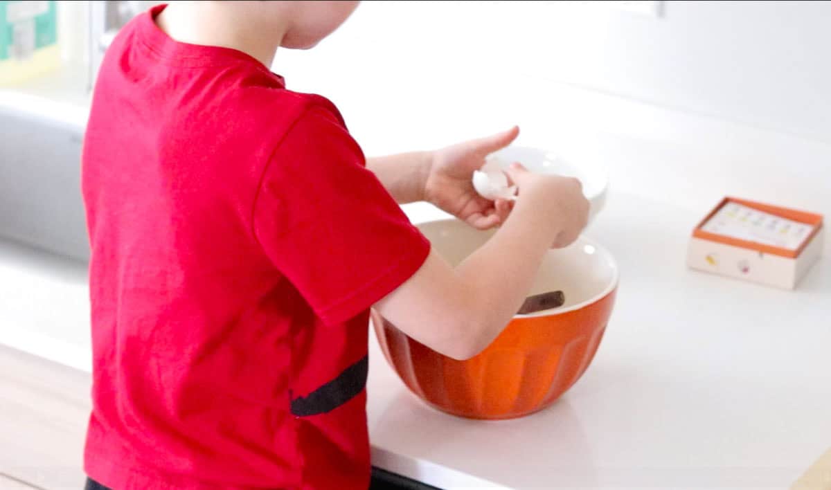 John is cracking eggs into a bowl
