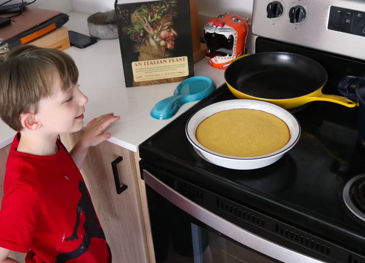 John is smiling at the ricotta timbale cooling on the stove
