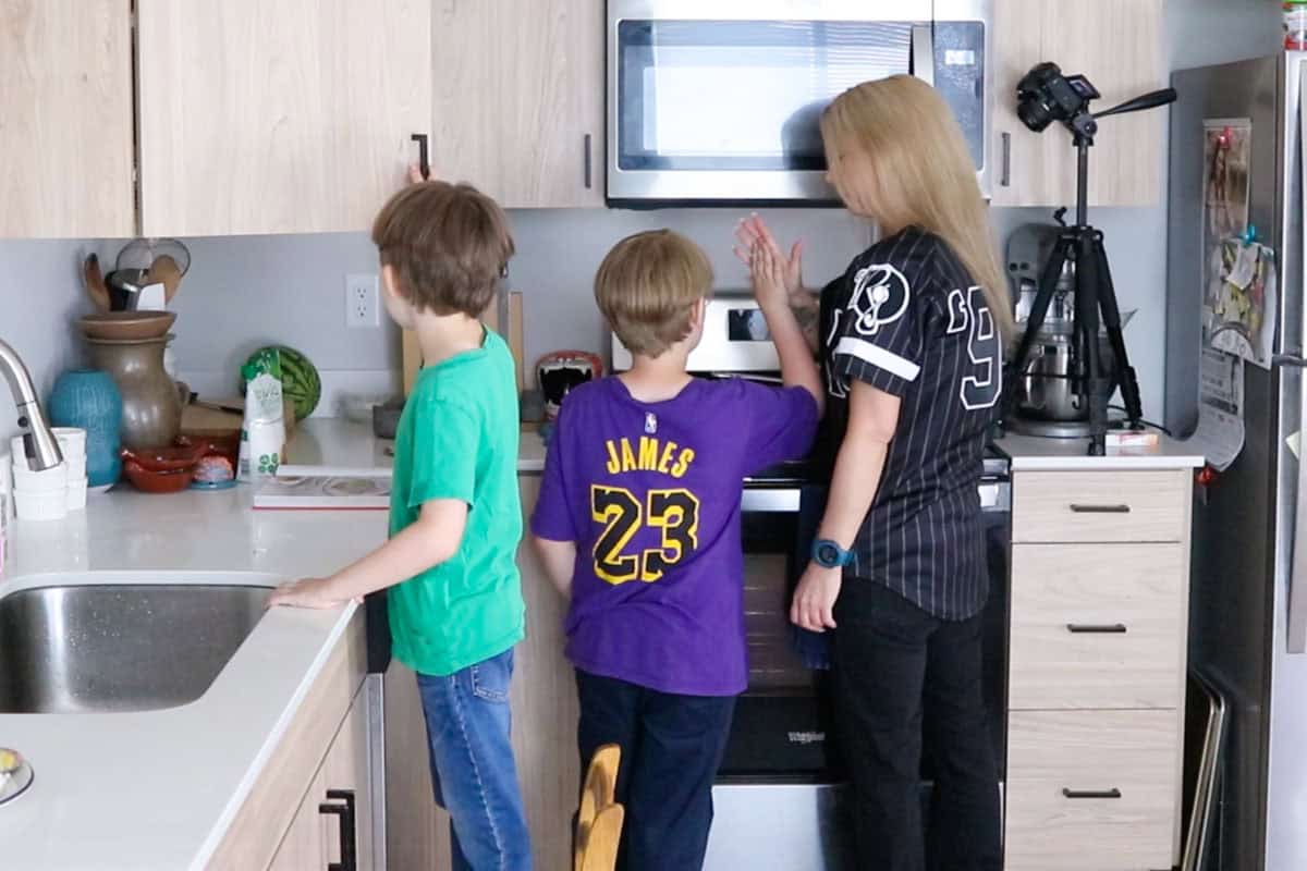 Kristin and Noah ae high-fiving after completing a task at the stove