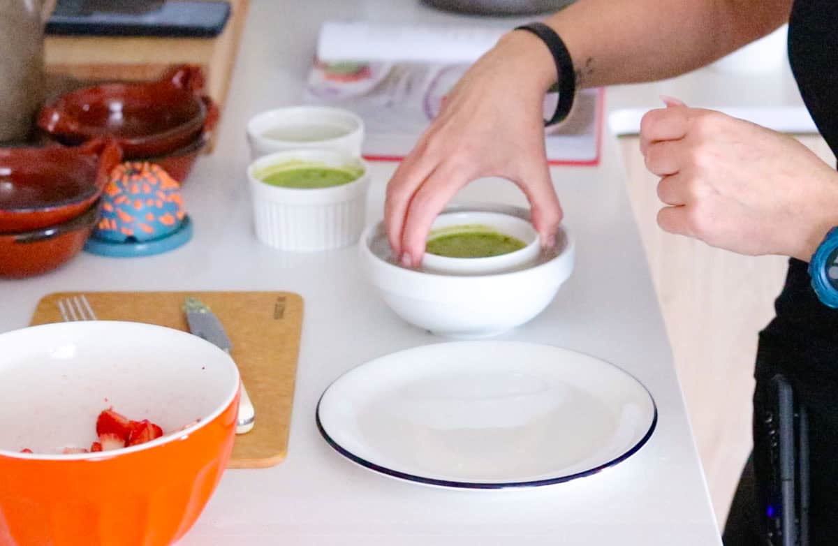 Kristin is dipping a panna cotta ramekin in hot water