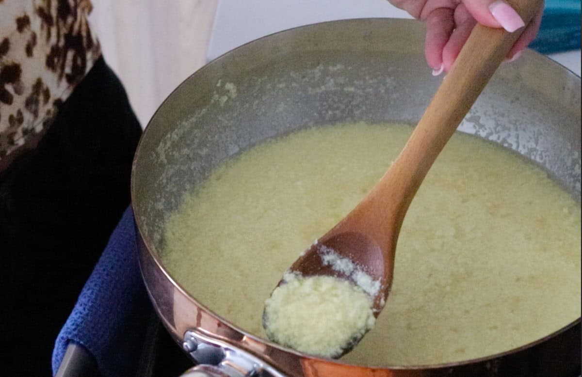 Kristin is showing the egg-drop soup to the camera using a spoon