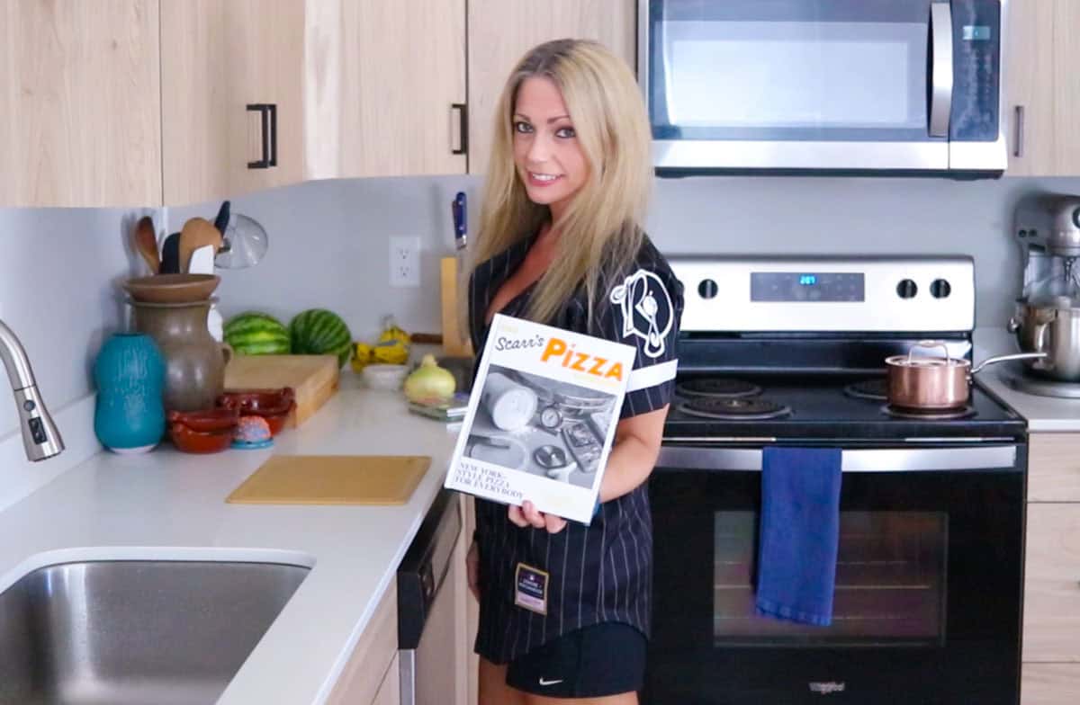 Kristin is showing The Scarr's Pizza Cookbook to the camera