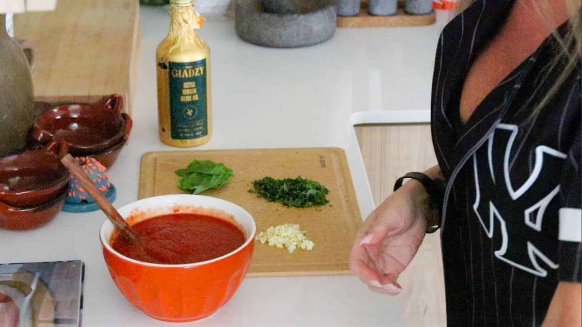 a tomato mixture in a bowl beside pizza sauce ingredients