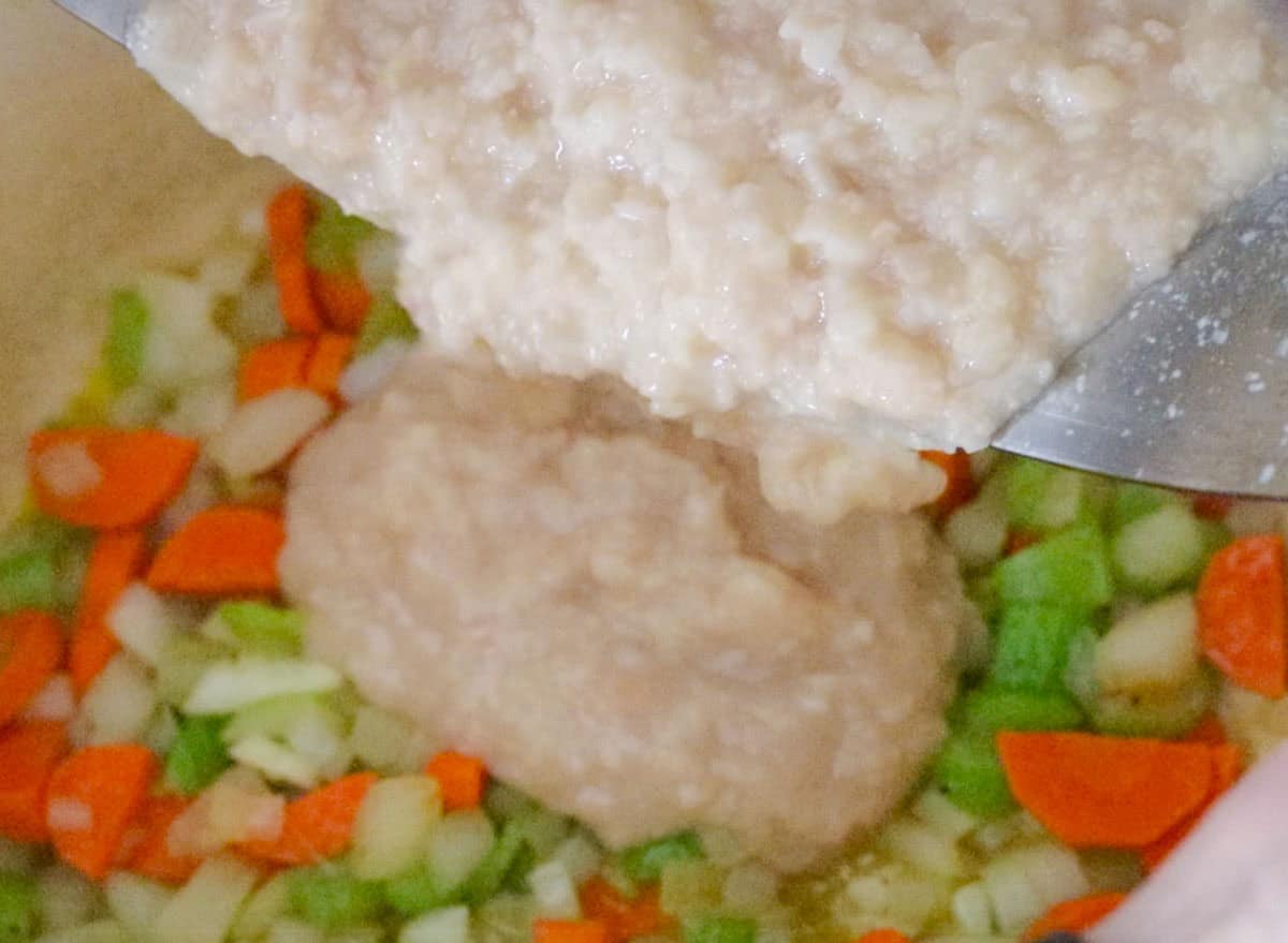 pouring cassoulet bean puree into Dutch oven