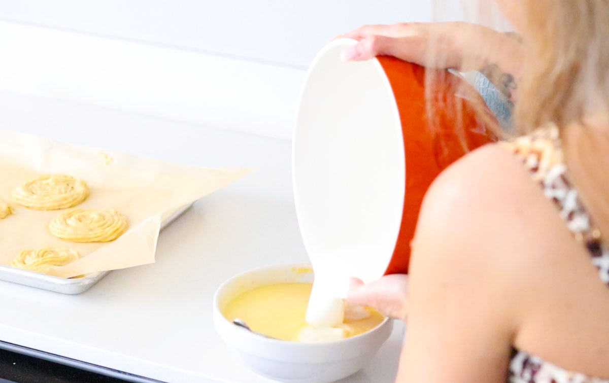 Kristin is adding milk to an egg mixture for custard