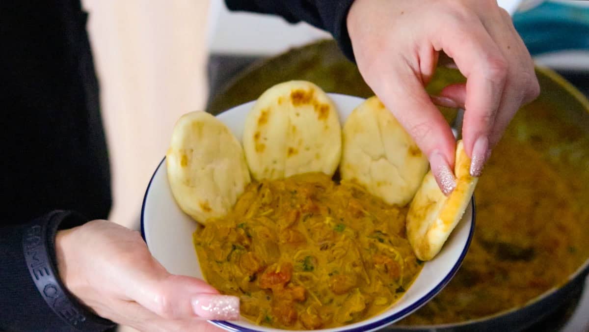 chicken tikka masala in a bowl with mini naan