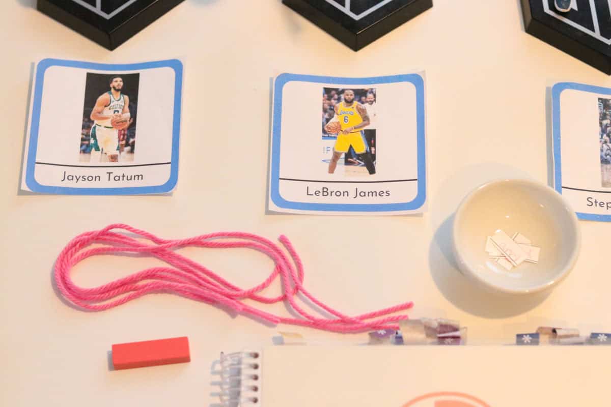 closeup of nba player cards, a Montessori conjunction grammar symbol, and pink yarn