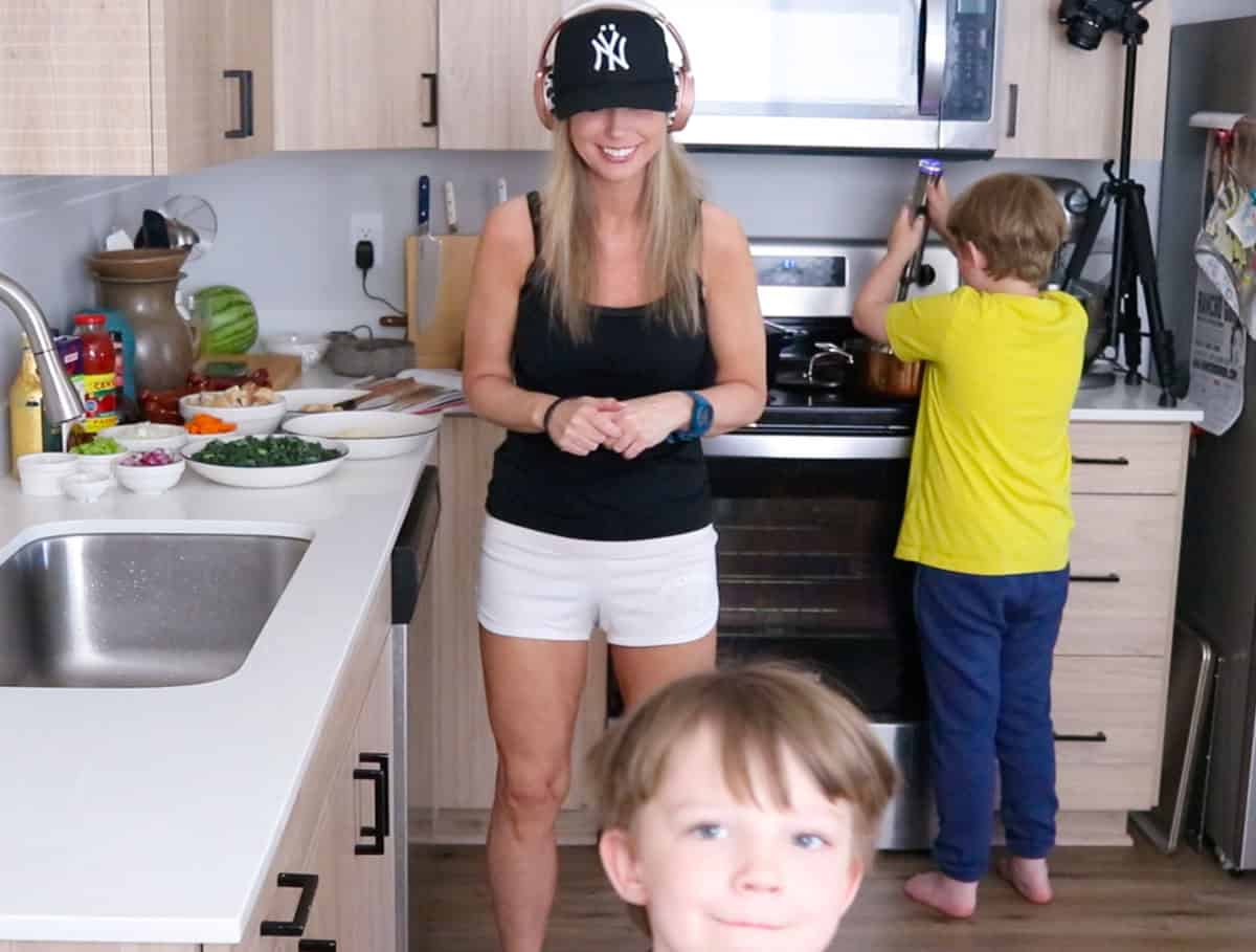 Kristin is watching John and listening to music while Noah uses an immersion blender to puree beans