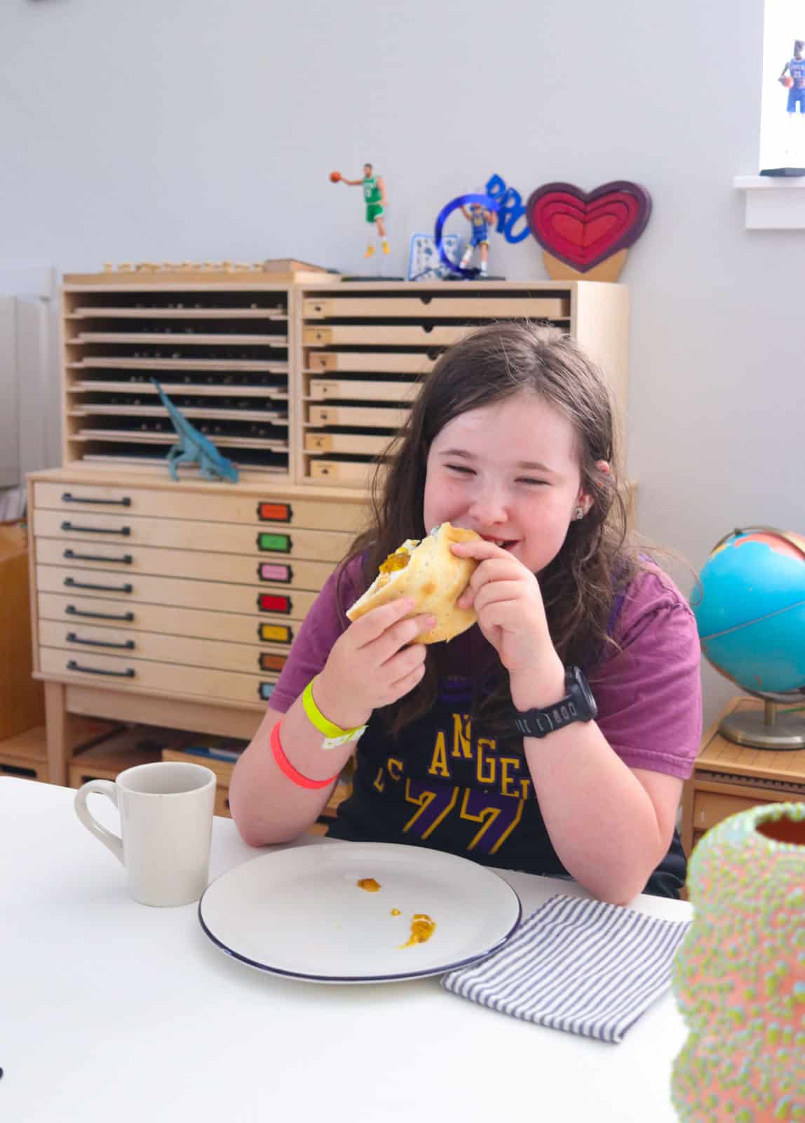 Kaia is happily eating her pb & mushroom pita sandwich