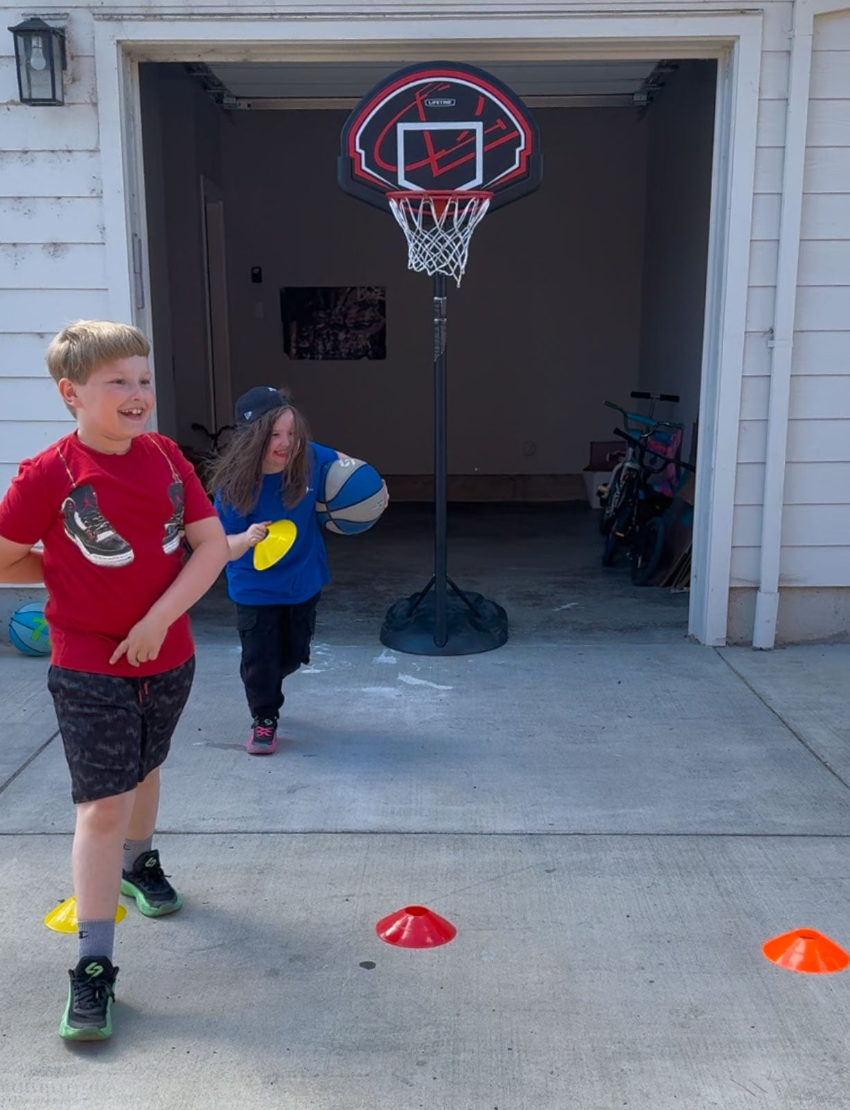 Kat is dashing away with a cone in the pick your shot game and Noah is laughing
