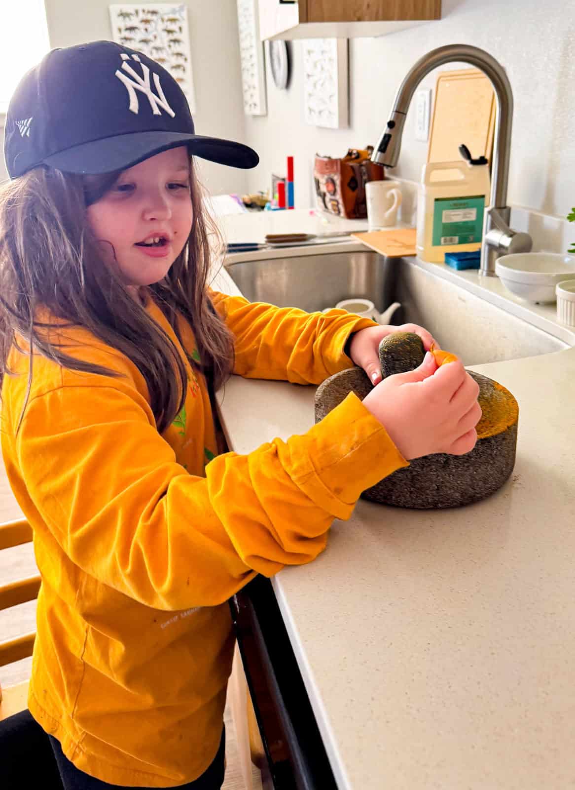 Kat is grinding spices in a molcajete