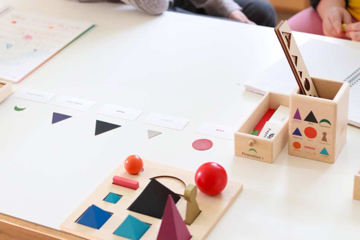 Montessori grammar symbols on a table with a prepositions drawer from the grammar cabinet