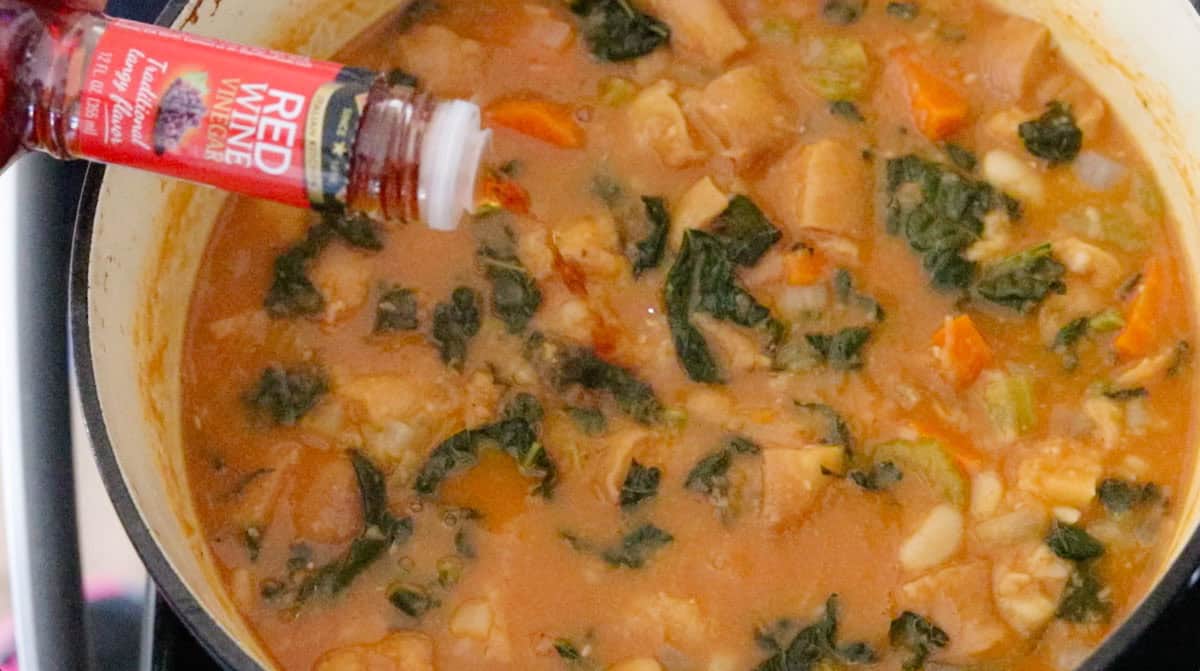 red wine vinegar over a Dutch oven with ribollita ingredients