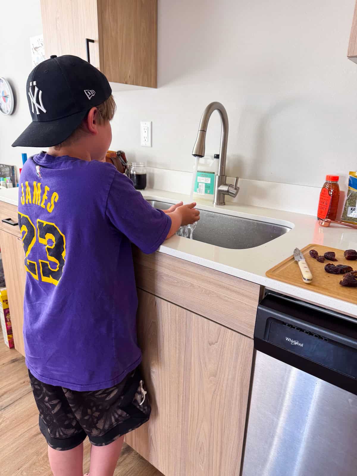 Noah is washing his hands after slicing some dates