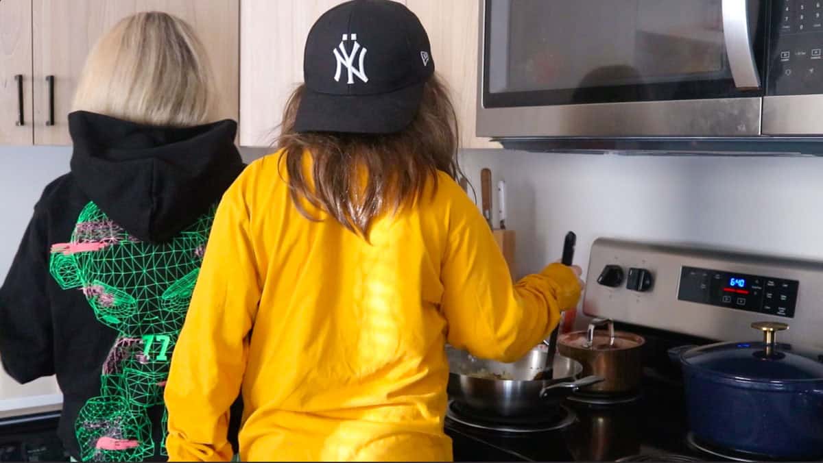 Kristin and Kat are working together to make chicken tikka masala sauce at the stove