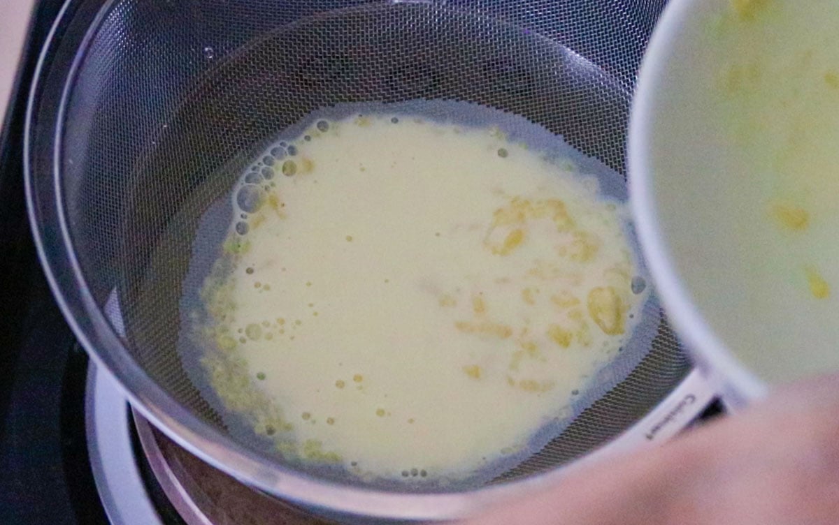 straining custard ingredients into a saucepan