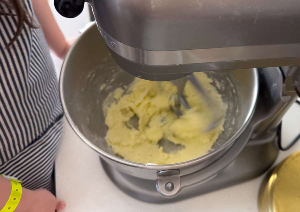 Kat is watching the stand mixer with the butter