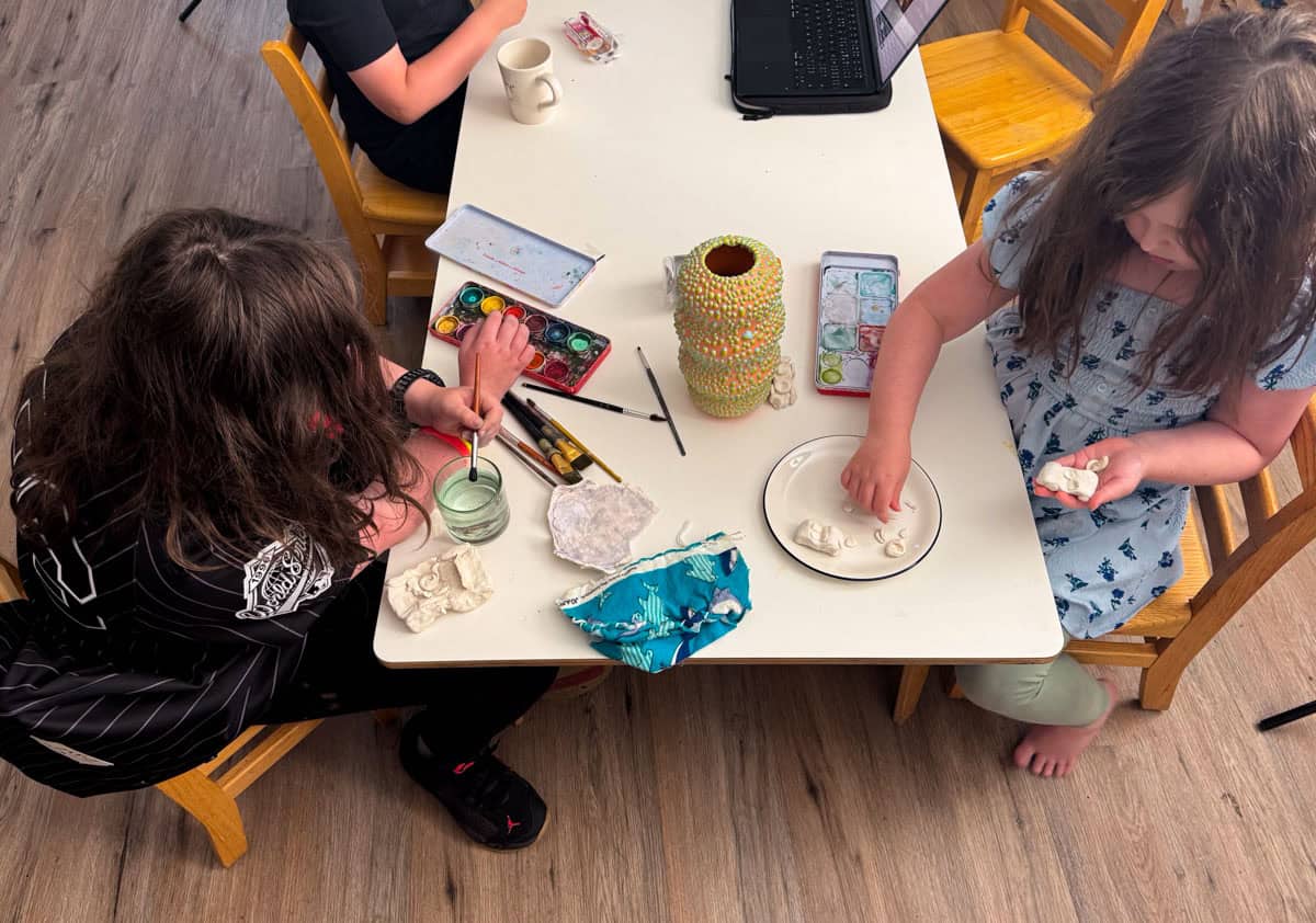 Kaia and Kat are painting their clay model sports cars with watercolor paints