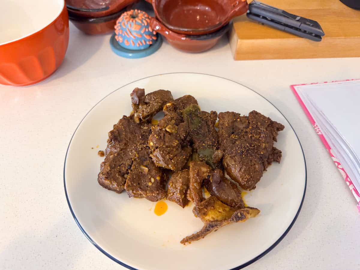 cooked lamb removed from a Dutch oven