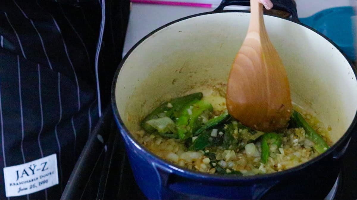 stirring peppers, onions, and garlic in a Dutch oven