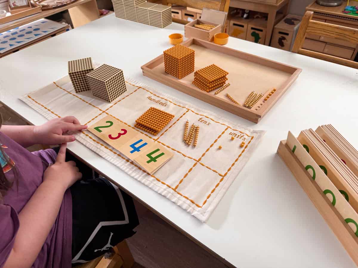 Montessori place value work with golden beads and numeral cards