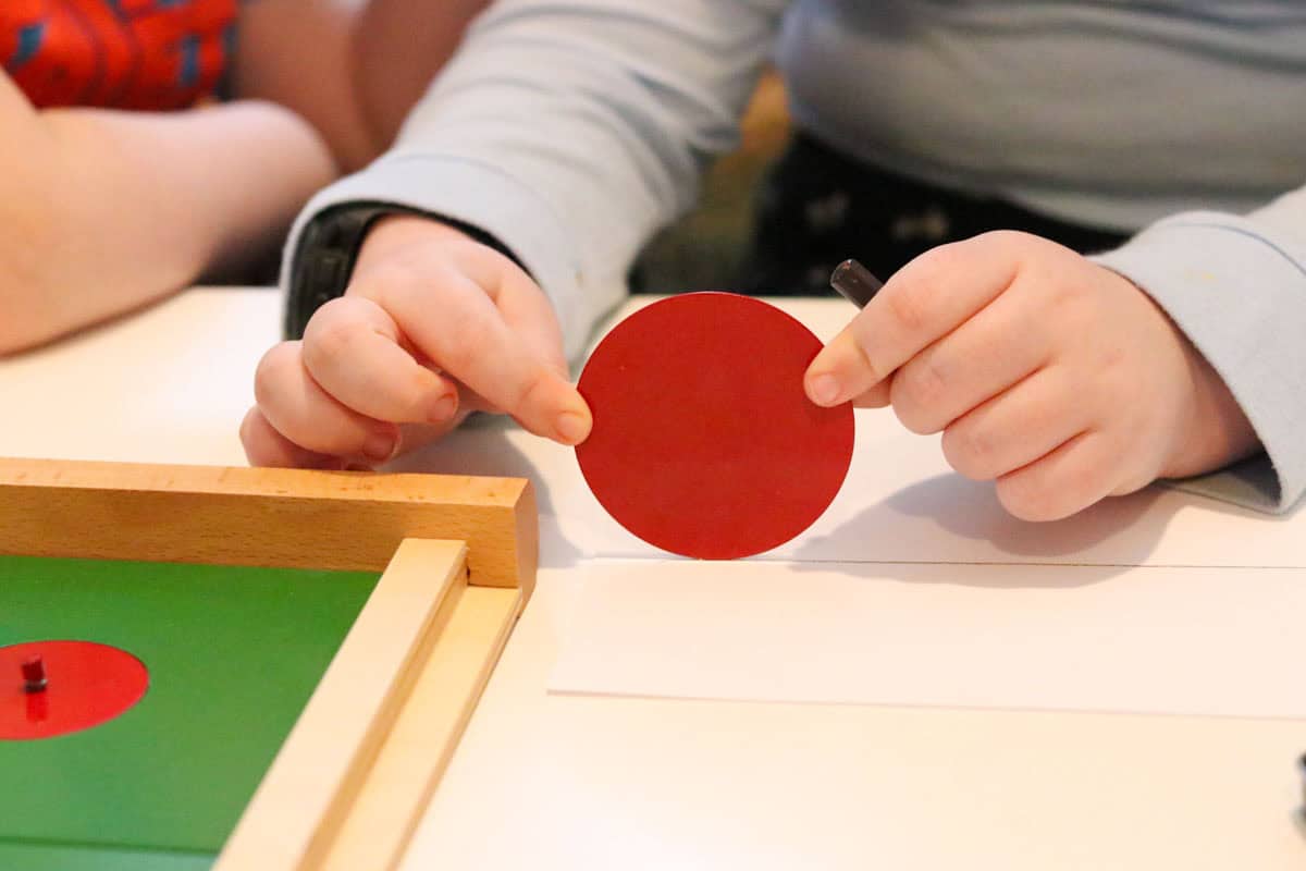 Kaia is tracing the circumference of a circle by rolling it across a lined piece of paper